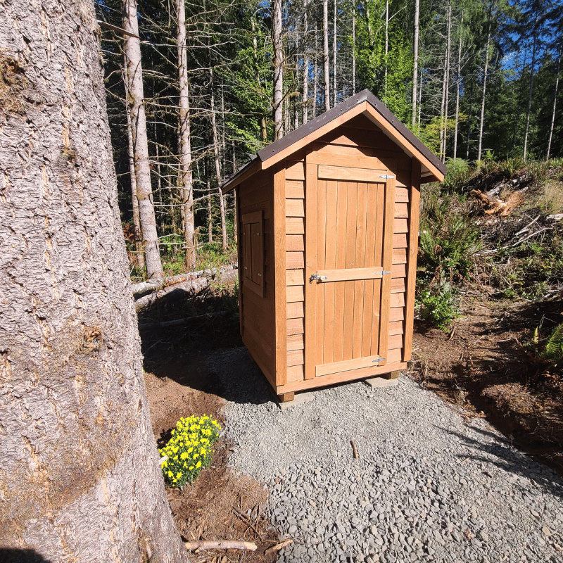Front and side view of the Oregon Timber Werks outhouse, highlighting the rustic design, craftsmanship, eco-friendly features, and suitability for homesteading